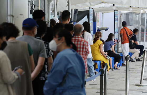 People wait in line to get tested for Covid-19 at a testing center in Mapo District, western Seoul, Friday. [YONHAP]