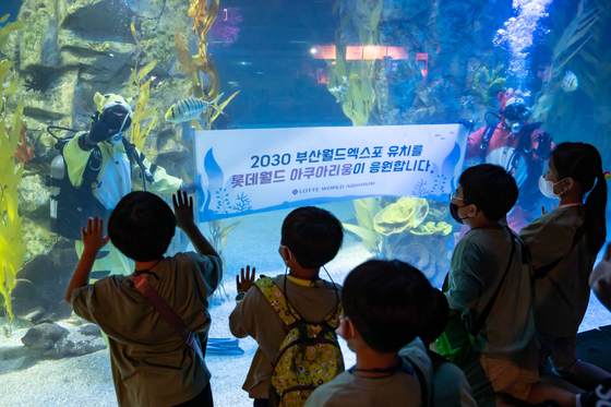 Children watch an underwater performance that shows support for Busan to host World Expo 2030 at the Lotte World Aquarium in Songpa District, southern Seoul on Monday. [YONHAP]