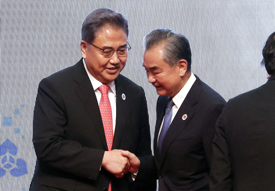 Foreign Minister Park Jin, left, and Chinese Foreign Minister Wang Yi shake hands after a photo session during the Asean Plus Three foreign ministerial meeting in Phnom Penh, Cambodia, on Thursday. [YONHAP] 