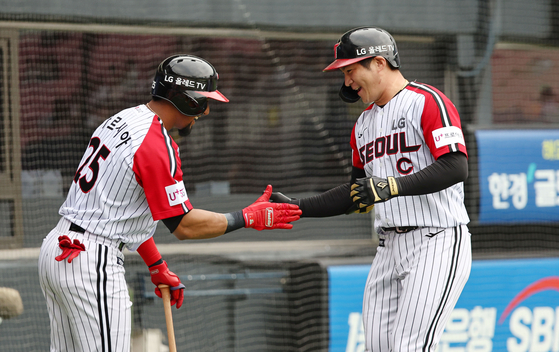 Oh Ji-hwan, right, celebrates with Robel Garcia after hitting a solo home run in a game against the Kiwoom Heroes at Jamsil Baseball Stadium in southern Seoul on Sunday. [YONHAP]
