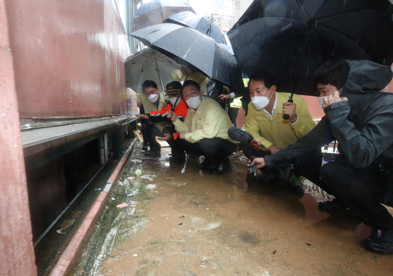 President Yoon Suk-yeol and Seoul Mayor Oh Se-hoon, second and third from left, inspect flood damage in Sillim-dong, Gwanak District, southern Seoul on Tuesday. [YONHAP]