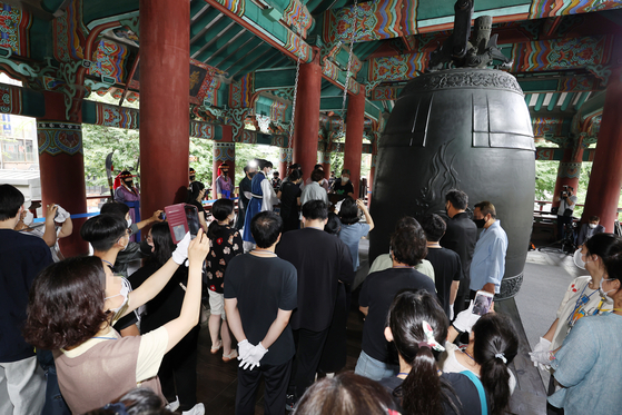 Parents ring the bell Tuesday at the Bosingak Pavilion in Jongno District, central Seoul, to pray for students to do well on the national College Scholastic Ability Test (CSAT), 100 days before the exam.[YONHAP]