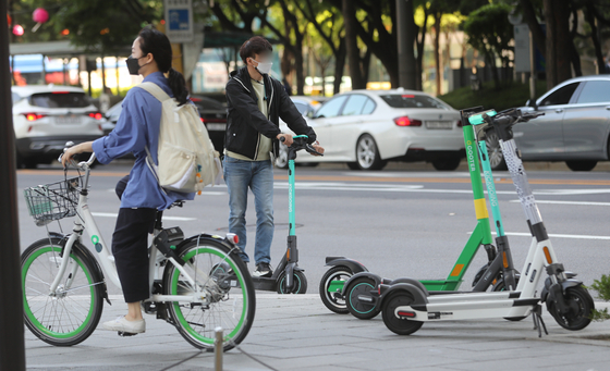 People are using public bike service Ttareungi and electric scooters without helmets in Seoul on May 12, 2021, a day before tighter regulations on personal mobility vehicles went into effect. [NEWS1]