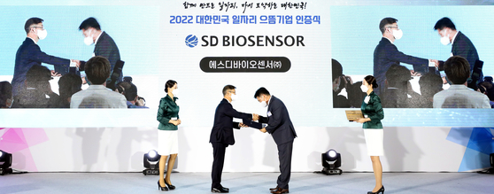 Minister of Employment and Labor Lee Jung-sik hands out certificates to companies at an event held at the Sejong Convention Center to certify good companies. [YONHAP]