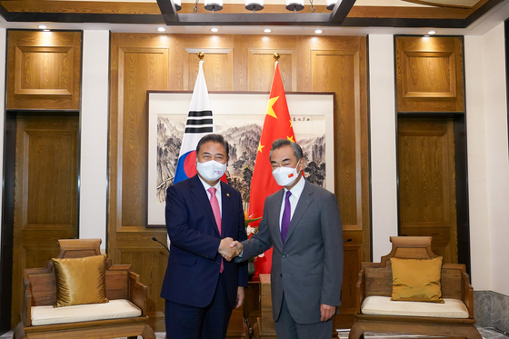 Foreign Minister Park Jin, left, and Chinese Foreign Minister Wang Yi shake hands in their meeting in Qingdao, Shandong Province, on Tuesday. [MINISTRY OF FOREIGN AFFAIRS]