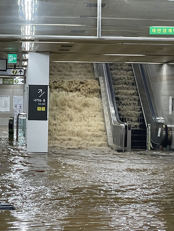 An exit at Isu Station in Dongjak District is flooded due to heavy rain Monday evening. [YONHAP]