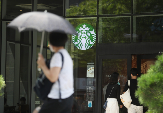 A passerby walks past a Starbucks branch in Seoul. [NEWS1]