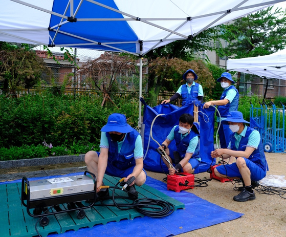 Employees of Samsung Electronics are checking household electronics damaged by the recent heavy rains. [SAMSUNG ELECTRONICS] 