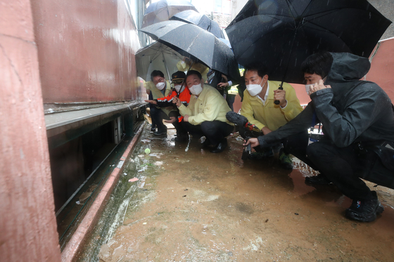 President Yoon Suk-yeol and Seoul Mayor Oh Se-hoon, second and third from left, inspect flood damage in Sillim-dong, Gwanak District, southern Seoul on Tuesday. [JOINT PRESS CORPS]