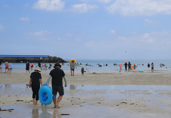 Beachgoers are shown wearing rash guards at Woljeongri Beach in Jeju Island on Aug. 7, 2022. [YONHAP]