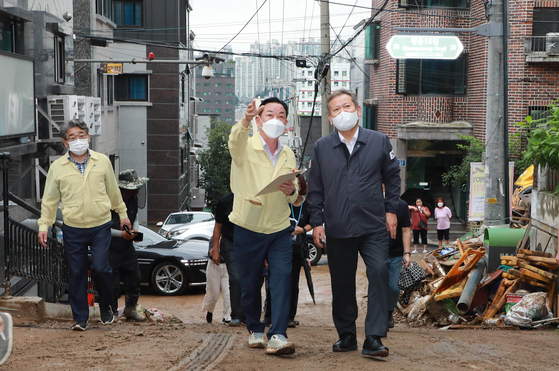 Minister of the Interior and Safety Lee Sang-min, right, inspects on Thursday a neighborhood in Gwanak District, southern Seoul, that was flooded due to torrential rains that poured Monday. [NEWS1]