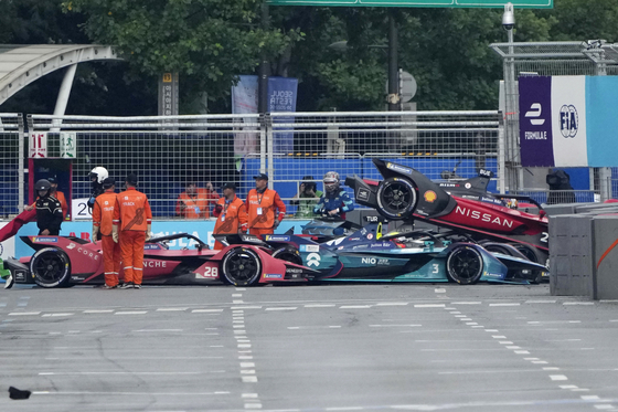 Track marshalls work near the cars of Avalanche Andretti driver Oliver Askew, Nio 333 driver Oliver Turvey and Nissan driver Sebastien Buemi after they crashed during the 2022 Hana Bank Seoul E-Prix in Jamsil, southern Seoul on Saturday. [AP/YONHAP]