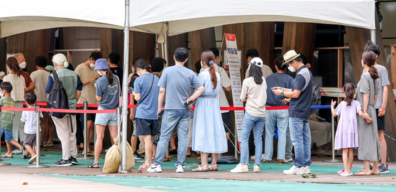People wait to be tested for Covid-19 at a testing center in Songap district, south Seoul, on Monday, a national holiday in Korea. [YONHAP]