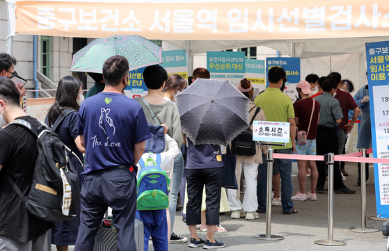 People wait to get tested for Covid-19 at a testing center erected outside Seoul Station in central Seoul on Sunday. [YONHAP]