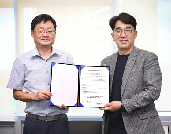 Cheong Chul-gun, left, CEO of the Korea JoongAng Daily, and Shin Woo-young, CEO of Global Education & Services, pose for a photo after signing a memorandum of understanding (MOU) in the newsroom in Sangam-dong, western Seoul, on Tuesday to cooperate in the Korean education market. [PARK SANG-MOON]