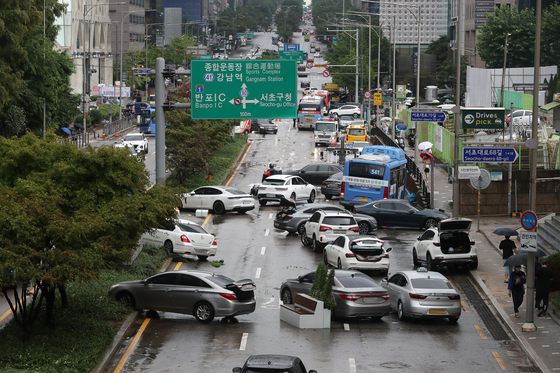 Cars are left abandoned in Seocho District, southern Seoul, on Tuesday after heavy rain on Monday. [NEWS1]