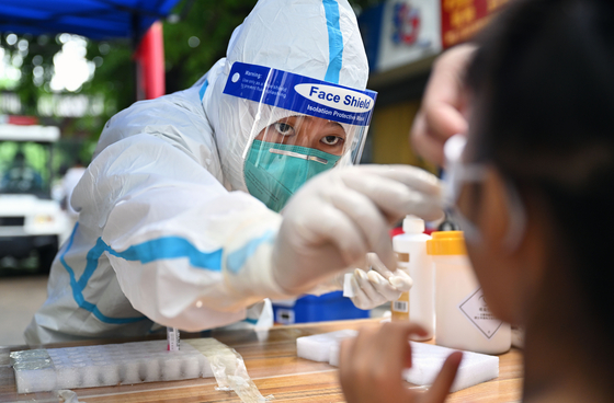 A medical professional conducts a test for the coronavirus in Sanya, China on Aug. 11.[YONHAP]