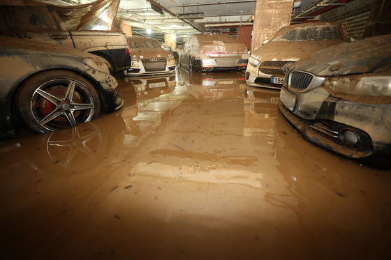 Cars are covered in mud in an underground parking lot in Seongnam, Gyeonggi on Wednesday due to the heavy rainfall that took place last week. [NEWS1] 