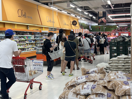 Customers line up at a Homeplus branch in Hapjeong, western Seoul, to buy the discount mart’s fried chicken on Wednesday. [LEE TAE-HEE]