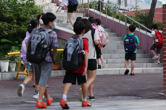 Students head to an elementary school in Seoul on Wednesday, as schools began to reopen nationwide amid the sixth wave of Covid-19 cases. [YONHAP]