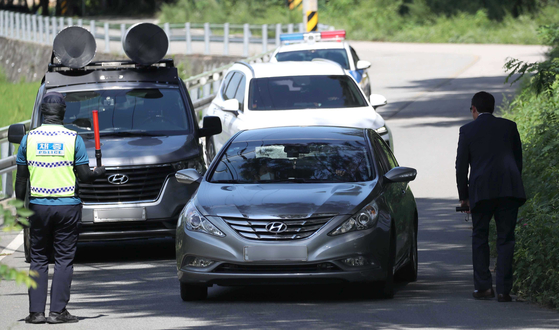 Members of the Presidential Security Service on Monday inspect vehicles entering Pyeongsan Village in Yangsan, South Gyeongsang, where former President Moon Jae-in’s retirement home is located. The security service expanded the guard zone around Moon's home by up to 300 meters to protect the former president from increasingly violent protests. [NEWS1]