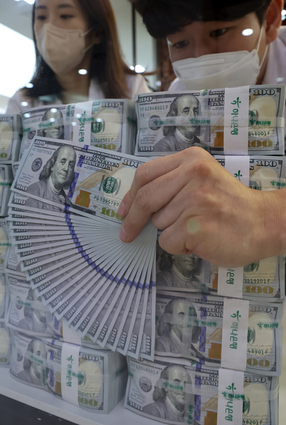 Employees sort out dollars at Hana Bank's Counterfeit Notes Response Center in Jung District, central Seoul, on Monday. The won broke 1,330 to the dollar for the first time in 13 years on Monday. The balance of resident foreign currency deposits in foreign exchange banks increased by $3.32 billion from the previous month. [YONHAP]
