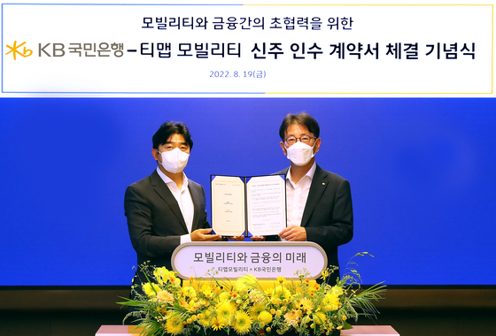 Lee Jong-ho, left, Tmap Mobility CEO, and Lee Jae-keun, KB Kookmin Bank CEO, pose for a photo during a signing ceremony held in Jongno District, central Seoul, Friday. [KB KOOKMIN BANK]