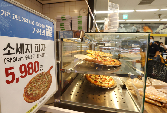 A sausage pizza is priced at 5,980 won ($4.45) at the Seongsu branch of Emart in Seongdong District, eastern Seoul, Monday. Following the popularity of affordable fried chicken buckets priced at 5,980 won per one whole chicken, Emart began to sell a limited amount of affordable pizza at the same price. [YONHAP]