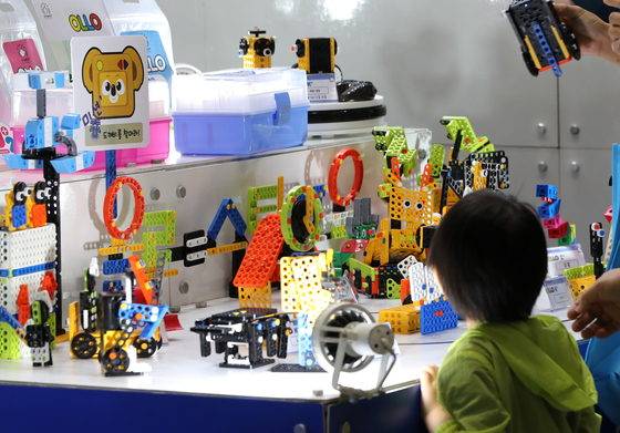 A child looks at an educational robot during the 2022 EduPlus Week, a fair to encourage the development of new educational content at the COEX convention center in Seoul on Aug. 11. [NEWS1]