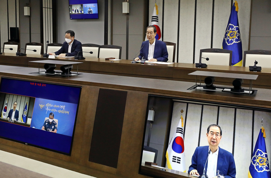 Prime Minister Han Duck-soo holds a video conference to discuss measures to respond to the recent suicide of a mother and her daughters in Suwon at the government complex in Sejong Tuesday. [NEWS1]