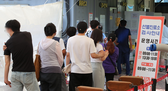 People wait in line at a Covid-19 testing site in Daejeon on Monday. [NEWS1]