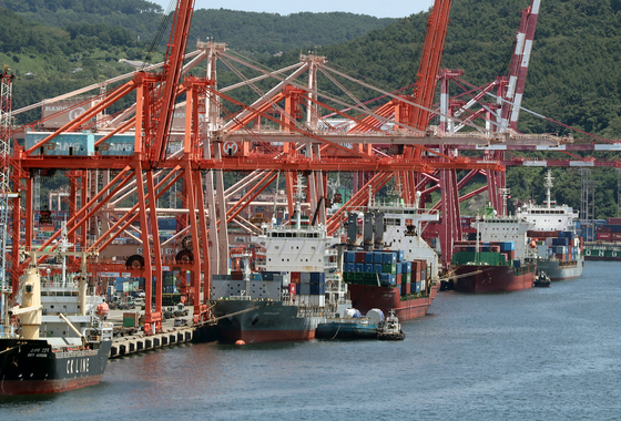 Containers are being loaded onto a ship at a pier in Busan on Monday. [YONHAP]