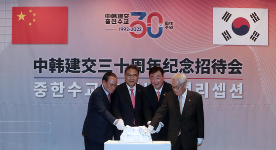 Foreign Minister Park Jin, center left, Chinese Ambassador to Korea Xing Haiming, center right, and other dignitaries cut a cake at the official ceremony marking the 30th anniversary of diplomatic relations between Korea and China at the Four Seasons Hotel in central Seoul Wednesday evening. A similar event was held simultaneously in Beijing. [JOINT PRESS CORPS]