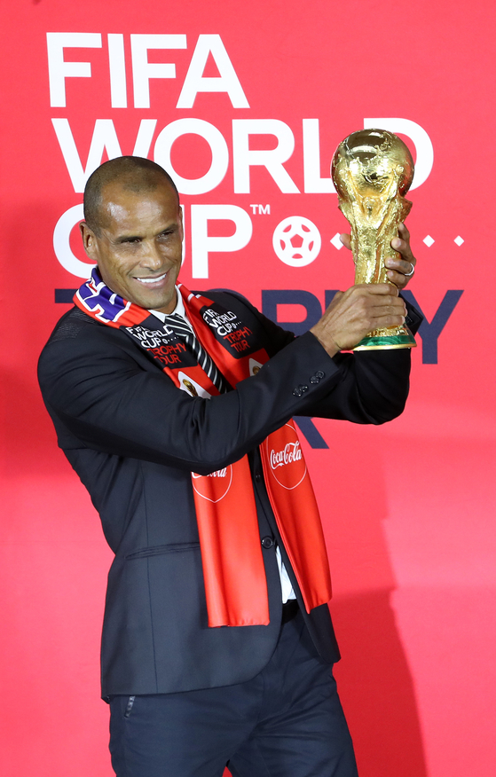 Brazilian football legend and 2002 World Cup winner Rivaldo poses with the World Cup trophy at The Hyundai Seoul in Yeouido, western Seoul on Wednesday. Only a very small group of people are permitted to touch the World Cup trophy, including former winners like Rivaldo and heads of state. [NEWS1]