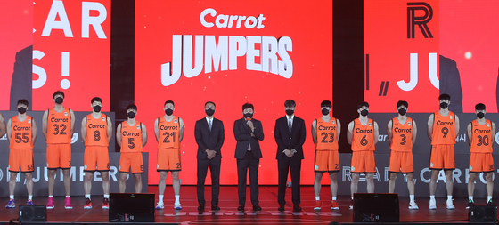 The coaching staff and players of the newly-minted Goyang Carrot Jumpers pose for a photo in the team's new uniform at Goyang Gymnasium in Goyang, Gyeonggi on Thursday. The club, formerly the Goyang Orion Orions, was recently purchased by Day One Asset Management, a unit of Daewoo Shipbuilding & Marine Engineering, which sold the naming rights to car insurance company Carrot Insurance. Despite the name, the club has selected a frog to be its new mascot. [NEWS1]
