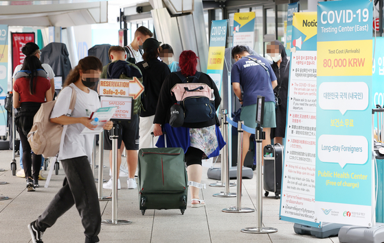 People wait in line to get tested for Covid-19 at Incheon International Airport's Terminal 1 on Wednesday. [YONHAP]