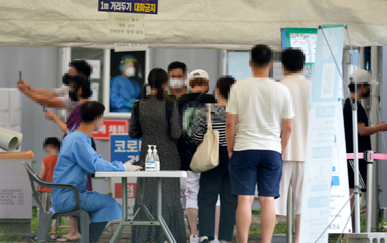People stand in line to get tested for Covid-19 in Daejeon on Thursday. [JOONGANG ILBO]