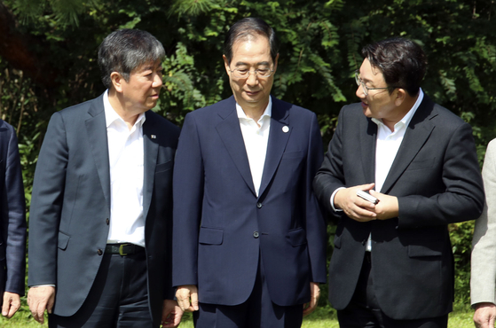 From left: Presidential Chief of Staff Kim Dae-ki, Prime Minister Han Duck-soo and People Power Party floor leader Kweon Seong-dong talk before a meeting at the prime minister's residence in Jongno District, central Seoul on Sunday. [KIM SEONG-RYONG]