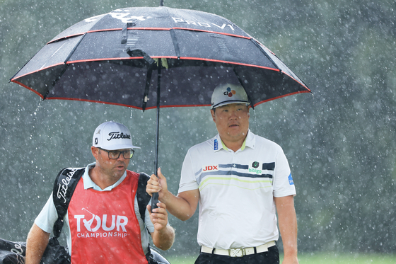 Im Sung-jae uses an umbrella on the second green during the first round of the Tour Championship at East Lake Golf Club on Thursday in Atlanta, Georgia. [GETTY IMAGES]