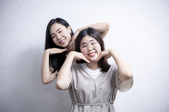 Oh Jung-hyun, behind, and Oh Ji-hyun, are sisters who run the YouTube channel Avopeach, pose during an interview at Yeonsinnae, Eunpyeong District, western Seoul. Ji-hyun is intellectually challenged and is active as a soprano in a vocal ensemble. [CHOI YOUNG-JAE] 