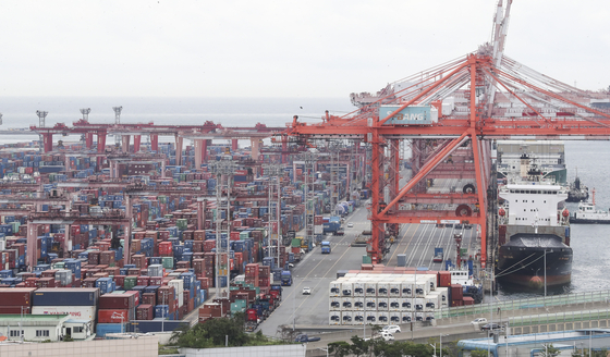 Containers are piled up at a port in Busan. [YONHAP]