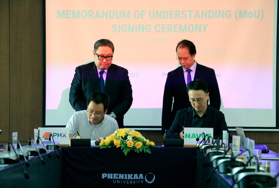 Le Anh Son, left in the front row, CEO of Vietnam's Phenikaa, and Kim Hyo, right, head of Naver Whale team, sign a memorandum of understanding at Phenikaa University in Hanoi on Friday. [NAVER]