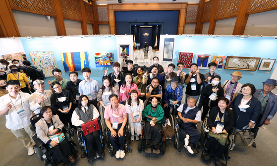 The disabled artists who attend the press conference for the exhibition on Wednesday pose for a picture in Chunchugwan of the Blue House. [MINISTRY OF CULTURE SPORTS AND TOURISM]