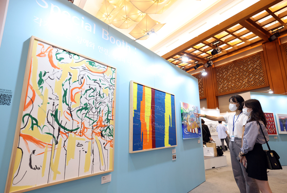 Visitors to the special exhibit at the Blue House enjoy the artworks by disabled artists on Wednesday. [MINISTRY OF CULTURE, SPORTS AND TOURISM]