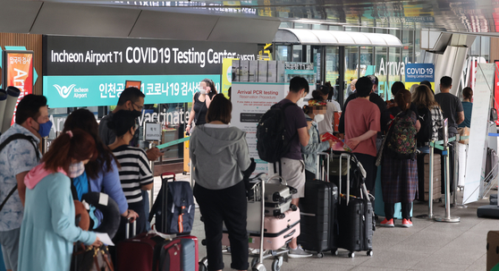 People wait to get tested for the coronavirus at a testing site in Incheon International Airport on Wednesday. [YONHAP]