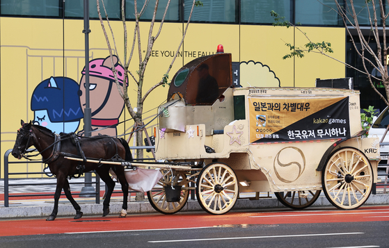 A horse-drawn carriage criticizing Kakao Games' Uma Musume Pretty Derby mobile game takes a spin around the Pangyo neighborhood in Gyeonggi, where Kakao Games is located, on Monday. [YONHAP]