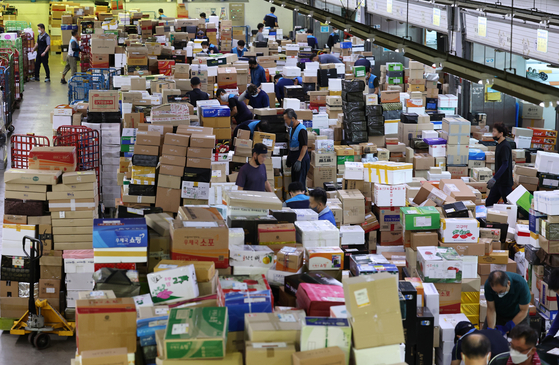 Ahead of the Chuseok harvest holidays, workers sort parcels at the East Seoul Post and Logistics Center in Gwangjin District, eastern Seoul, on Thursday. Korea Post estimated that 19.17 million parcels will be posted for Chuseok this year, adding 30,000 additional workers and 800 additional vehicles for delivery. [YONHAP]