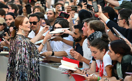 Actor Julianne Moore signs autographs as she arrives for the opening ceremony and screening of ″White Noise″ at the 79th annual Venice International Film Festival, in Venice, Italy, on Aug. 31. [EPA/YONHAP]
