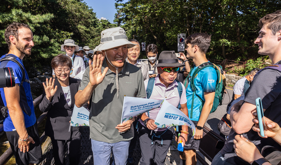 Seoul Mayor Oh Se-hoon, center, greets hikers at the foot of Mount Bukhan in Seoul on Thursday after attending an opening ceremony of an information center for mountain climbers. [YONHAP]