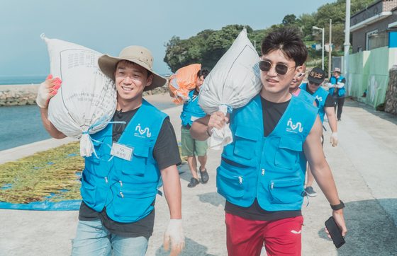 Youn Seung-chul, left, and volunteers pick up after ocean debris on Pung Island near Ansan, Gyeonggi, in September 2018. [YOUN SEUNG-CHUL] 